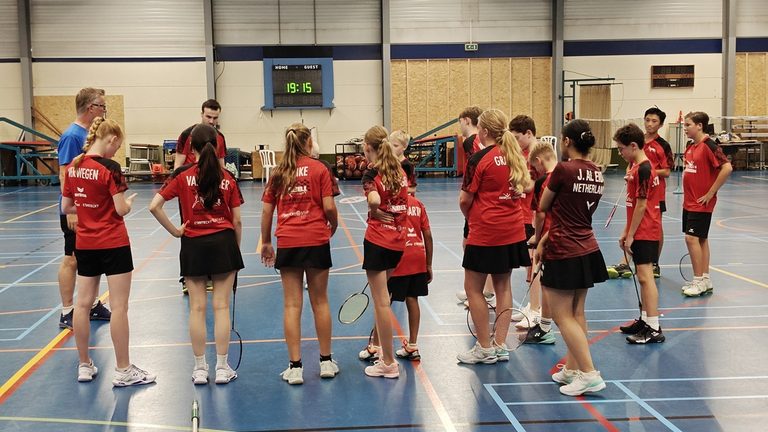 Groep spelers luistert naar de trainer